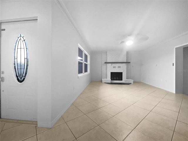 unfurnished living room featuring ceiling fan, light tile patterned flooring, ornamental molding, and a fireplace