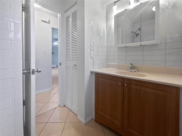 bathroom featuring tasteful backsplash, tile patterned flooring, and vanity