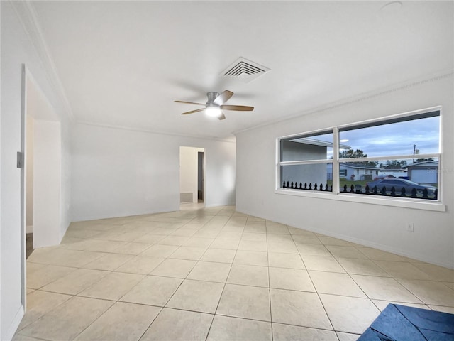 tiled empty room featuring ceiling fan and ornamental molding