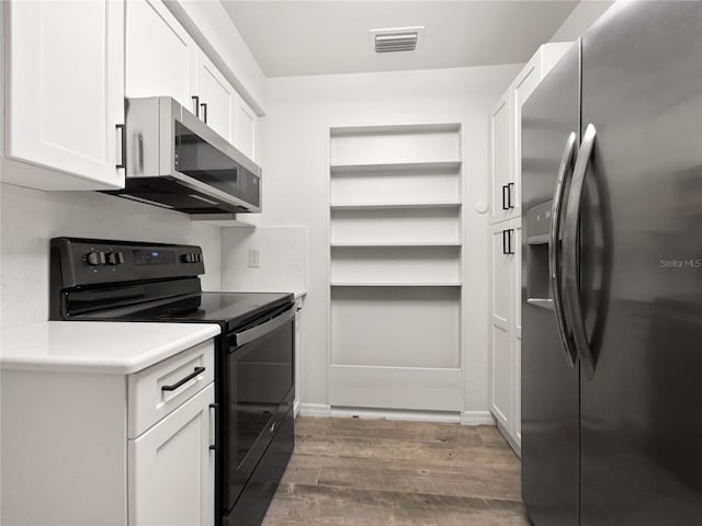 kitchen with white cabinets, dark hardwood / wood-style floors, and appliances with stainless steel finishes