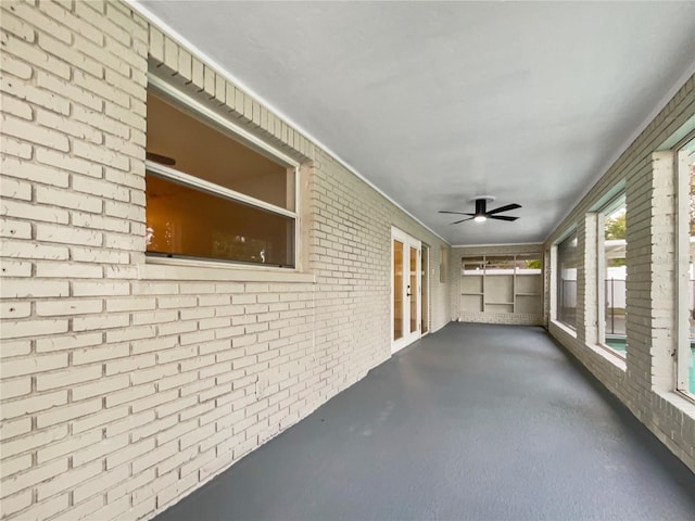 unfurnished sunroom with ceiling fan