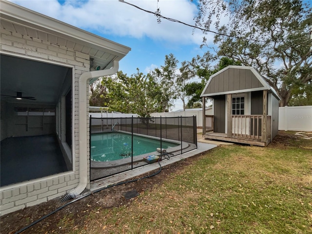 view of pool with a lawn and an outdoor structure