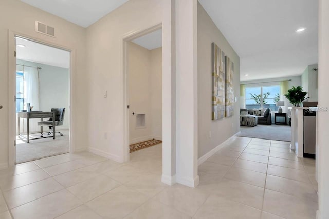 hall with light tile patterned floors