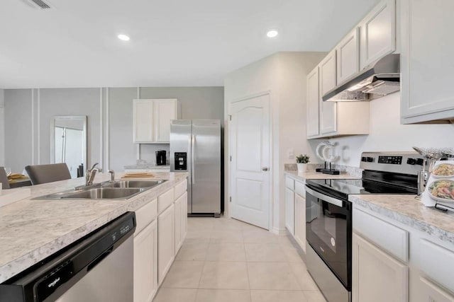 kitchen with sink, white cabinetry, appliances with stainless steel finishes, and light tile patterned flooring