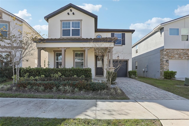 view of front of home featuring a garage, covered porch, and central AC