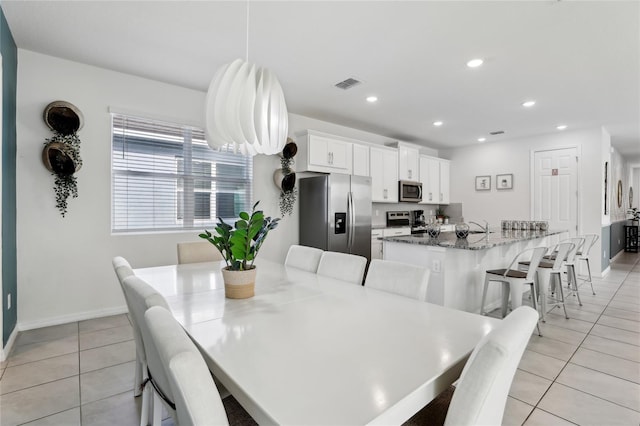 dining space featuring sink and light tile patterned flooring