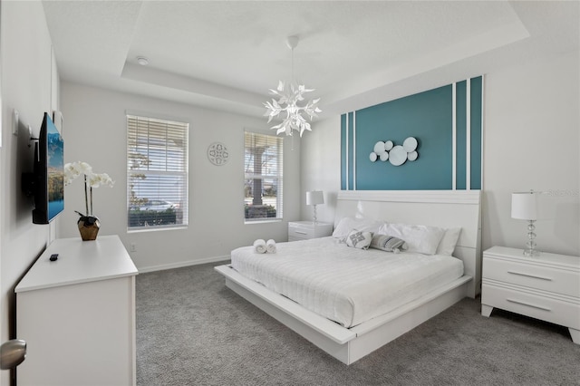 bedroom with a tray ceiling, light carpet, and a notable chandelier