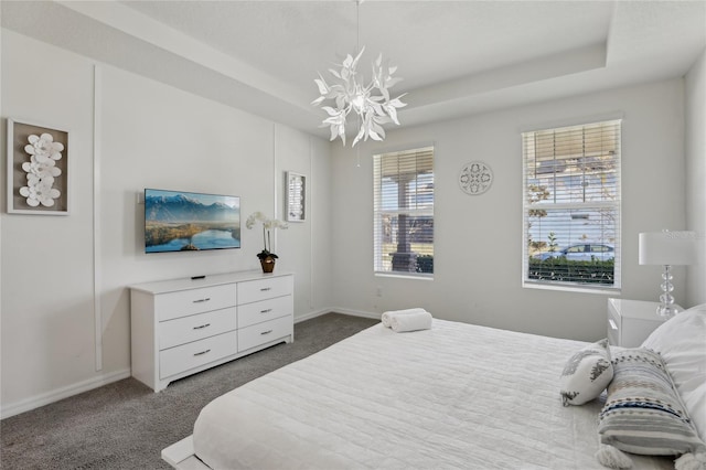 carpeted bedroom with a raised ceiling