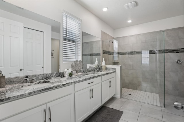 bathroom featuring vanity, tiled shower, and tile patterned floors