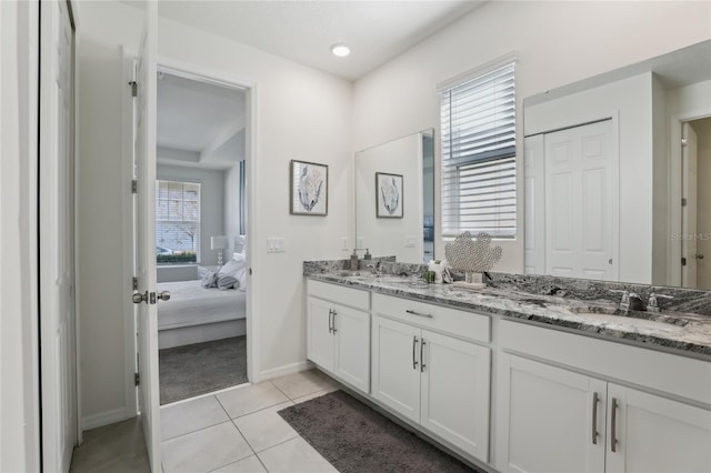 bathroom featuring vanity, a healthy amount of sunlight, and tile patterned floors