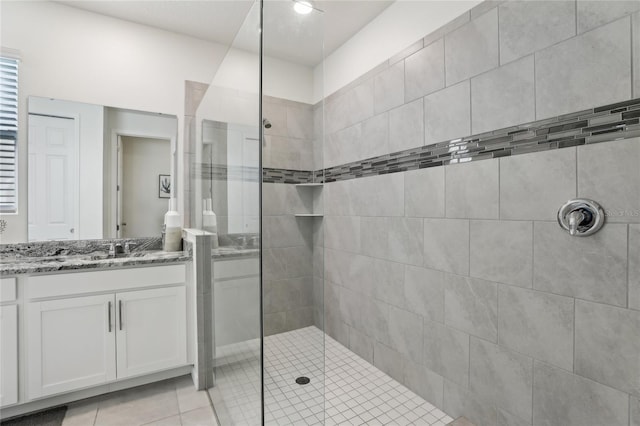 bathroom with vanity, tile patterned floors, and a tile shower