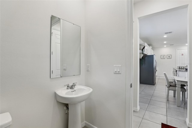 bathroom with sink, toilet, and tile patterned floors