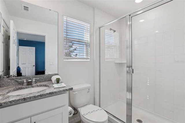 bathroom with vanity, toilet, and an enclosed shower