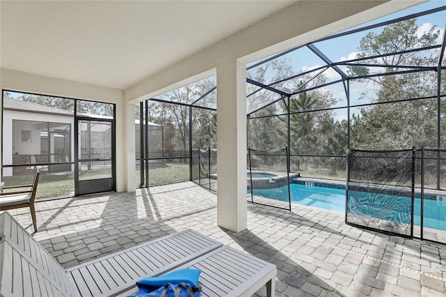 view of pool with glass enclosure, an in ground hot tub, and a patio area