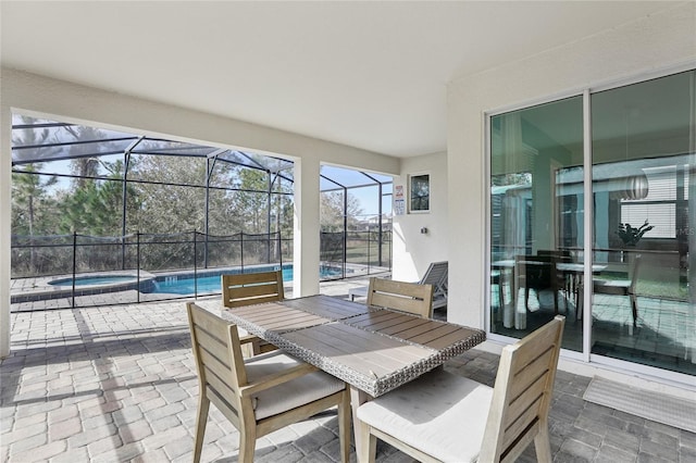 view of patio / terrace featuring glass enclosure and a swimming pool with hot tub