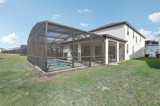 rear view of property featuring glass enclosure, a lawn, a pool with hot tub, and a patio