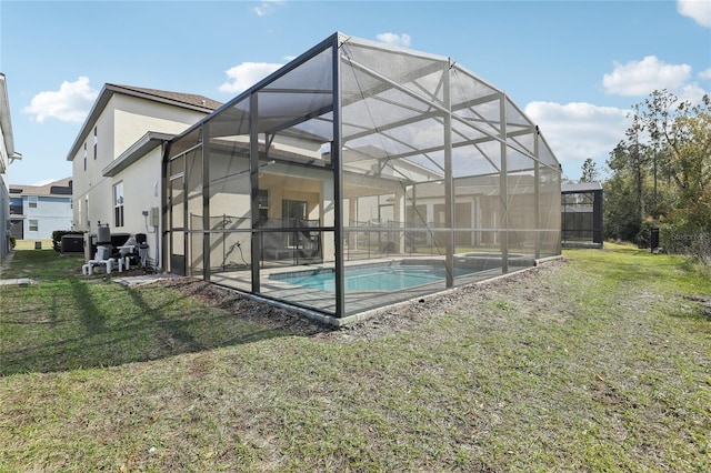 rear view of property featuring glass enclosure and a lawn