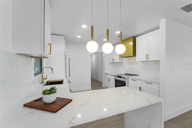 kitchen with stainless steel electric range oven, decorative light fixtures, sink, white cabinets, and light stone countertops