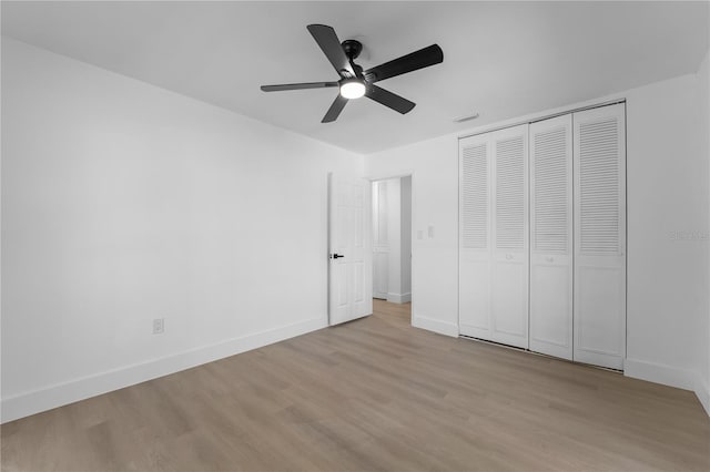 unfurnished bedroom with ceiling fan, light hardwood / wood-style floors, and a closet