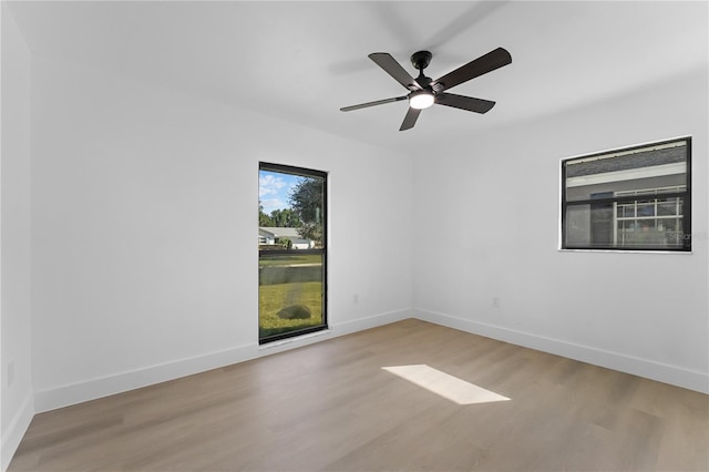 empty room with ceiling fan and light hardwood / wood-style flooring