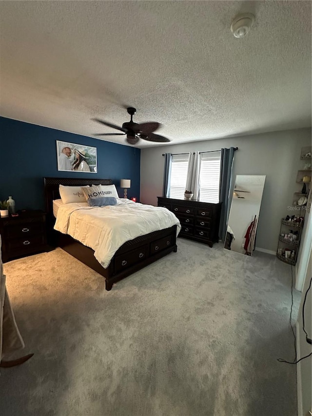 bedroom with carpet, a textured ceiling, and ceiling fan