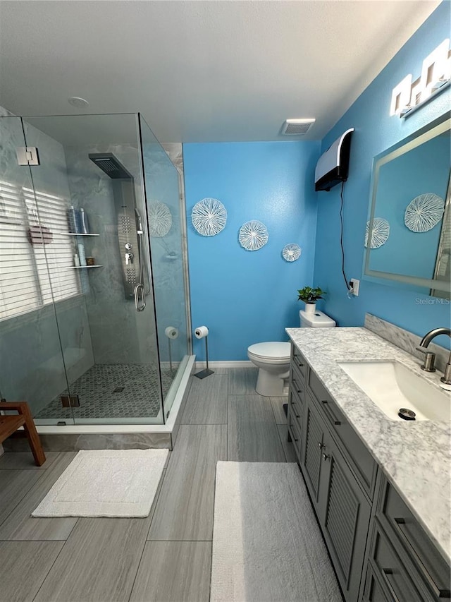 bathroom with toilet, walk in shower, and vanity