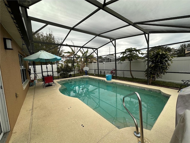 view of pool with glass enclosure and a patio