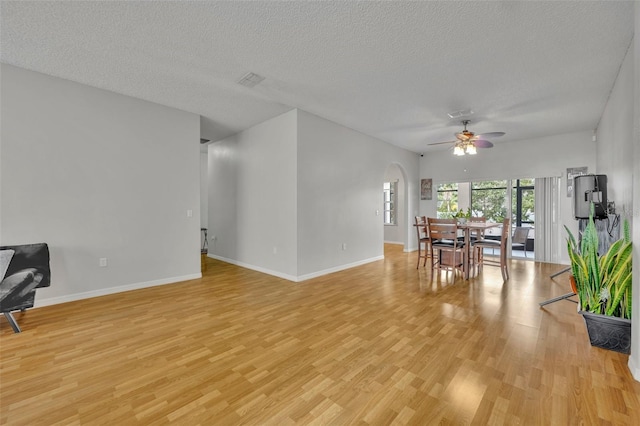 interior space with ceiling fan, a textured ceiling, and light hardwood / wood-style floors