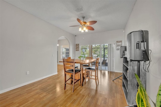 dining space featuring light hardwood / wood-style floors, a textured ceiling, and ceiling fan