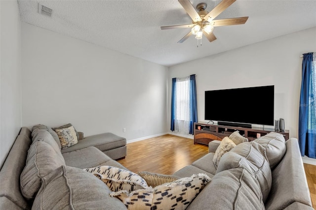 living room featuring a textured ceiling, ceiling fan, and hardwood / wood-style floors