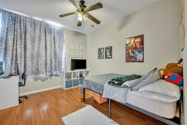 bedroom with ceiling fan, a textured ceiling, and hardwood / wood-style flooring