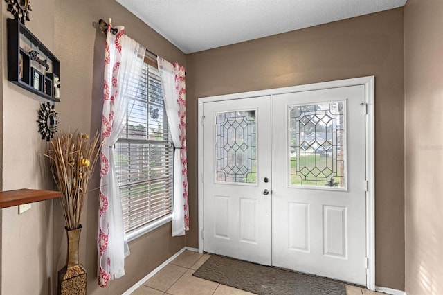 foyer entrance featuring light tile patterned floors and french doors