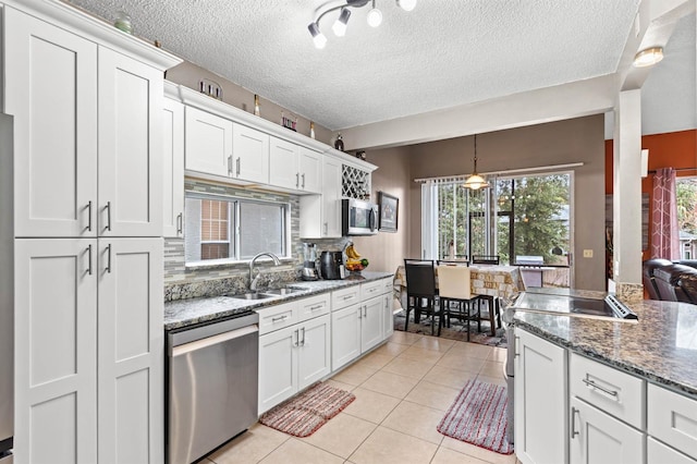 kitchen featuring stainless steel appliances, sink, white cabinets, and decorative backsplash