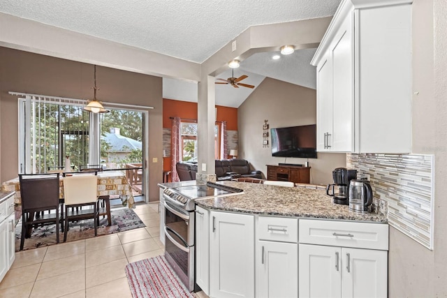 kitchen featuring vaulted ceiling, white cabinets, backsplash, double oven range, and light stone counters