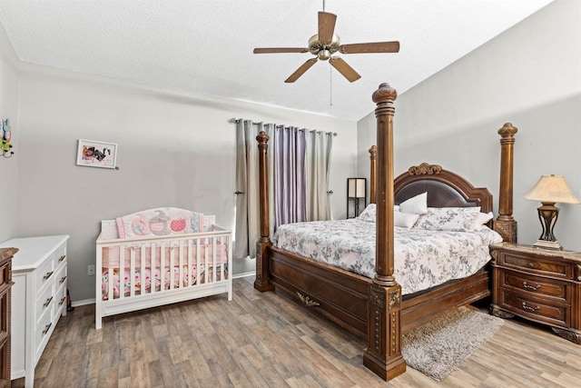 bedroom featuring hardwood / wood-style flooring, a textured ceiling, and ceiling fan