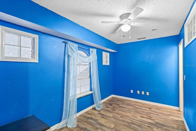 unfurnished room with ceiling fan, hardwood / wood-style floors, and a textured ceiling