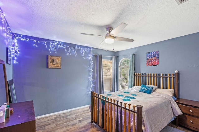 bedroom featuring wood-type flooring, a textured ceiling, and ceiling fan