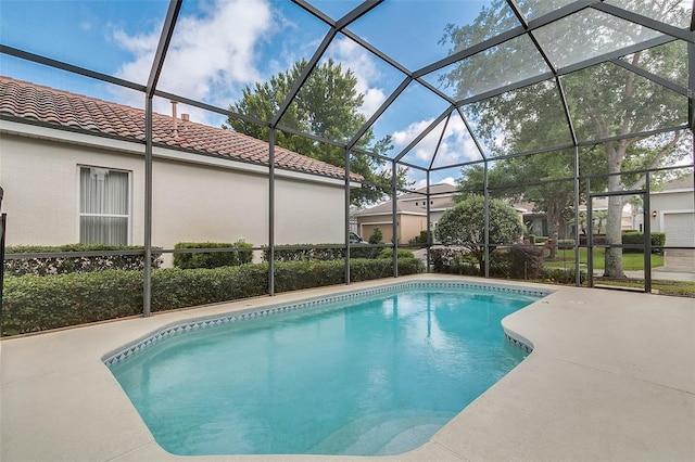 view of swimming pool featuring glass enclosure and a patio area