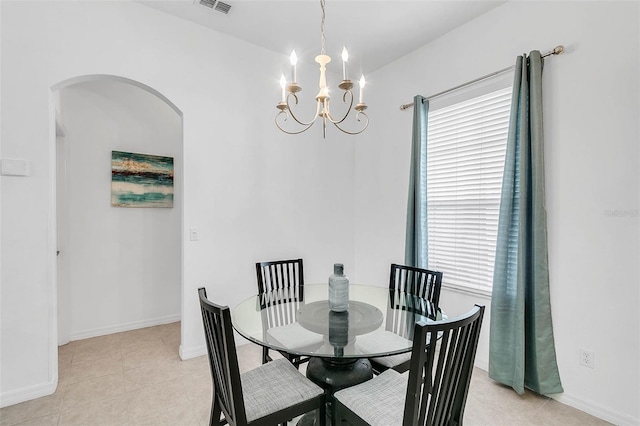 dining space featuring light tile patterned floors and an inviting chandelier