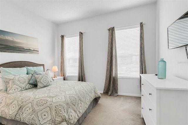 carpeted bedroom featuring multiple windows