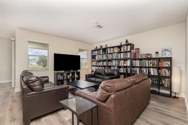 living room featuring light hardwood / wood-style floors and a textured ceiling