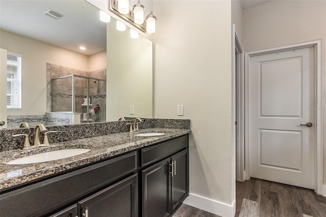 bathroom with hardwood / wood-style floors, an enclosed shower, and vanity