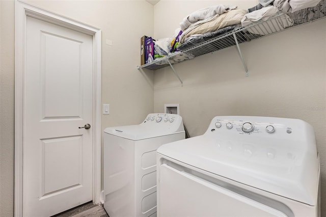 laundry area with hardwood / wood-style floors and washing machine and clothes dryer