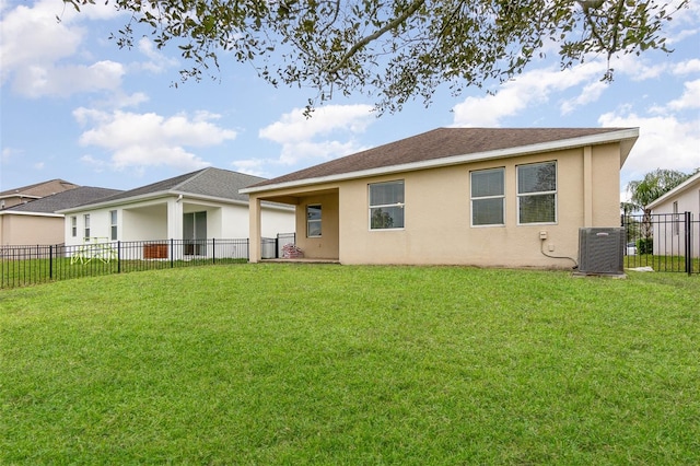 rear view of property featuring central air condition unit and a yard