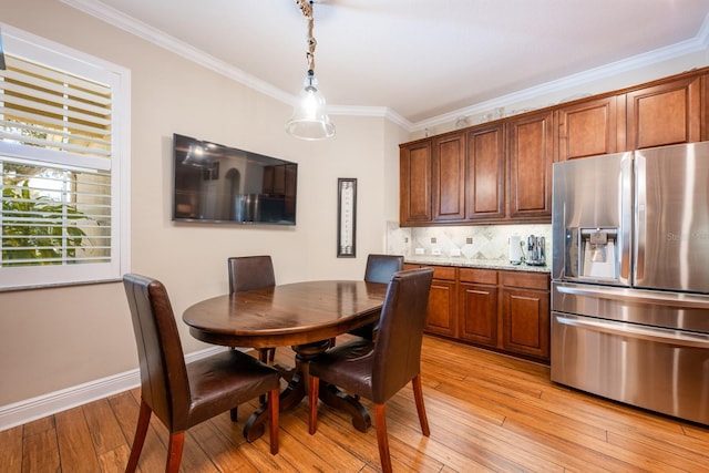 dining room featuring crown molding and light hardwood / wood-style floors