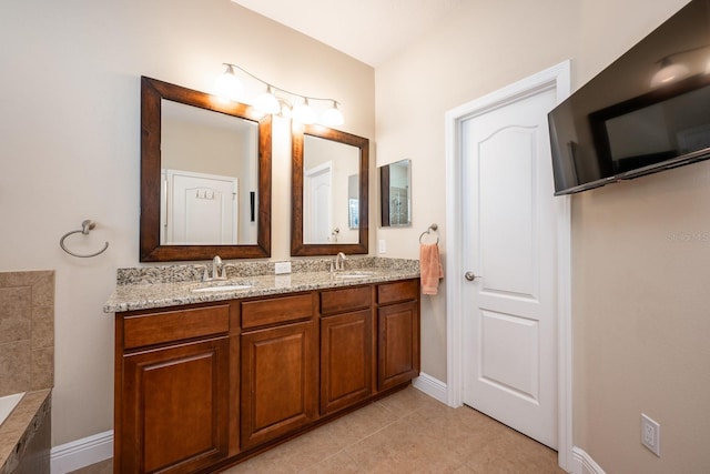 bathroom featuring tile patterned floors, vanity, and a bathing tub