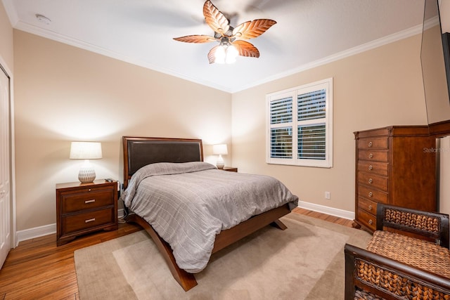 bedroom with light hardwood / wood-style flooring, ornamental molding, and ceiling fan