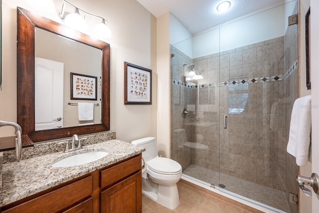 bathroom with vanity, toilet, tile patterned floors, and a shower with shower door