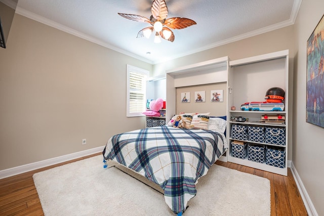 bedroom with ceiling fan, ornamental molding, and hardwood / wood-style floors