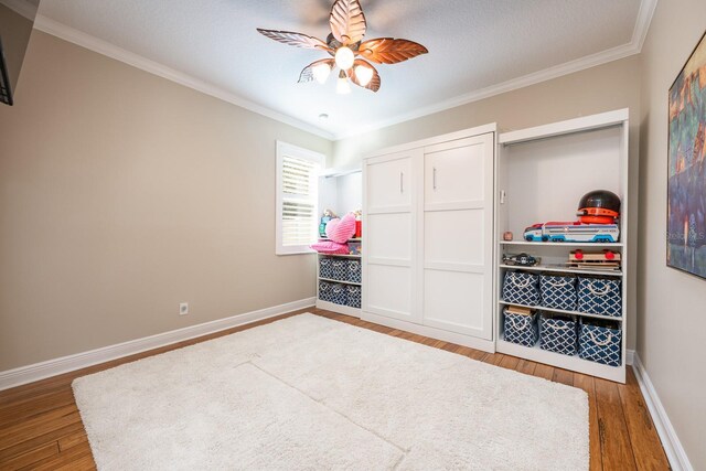 bedroom with hardwood / wood-style flooring, ornamental molding, a closet, and ceiling fan